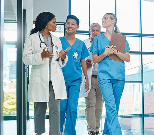 Healthcare, doctors and nurses walking together for discussion, planning or schedule. Diversity, men or women medical group talking about support strategy,